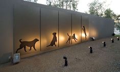 the silhouettes of people and dogs are lit up on the side of a building