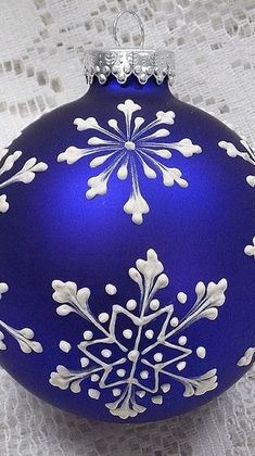 a blue ornament with white snowflakes on it sitting on a table