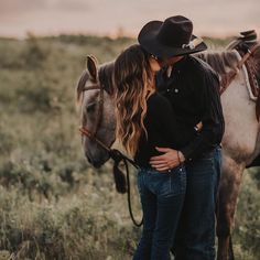 a man and woman standing next to each other in front of a horse on a field