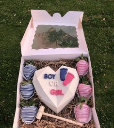 a box filled with baby's first birthday decorations and strawberries on the ground