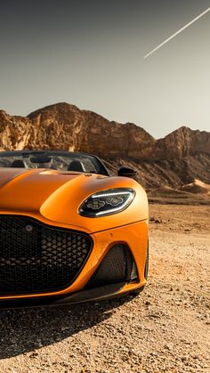 an orange sports car parked in the desert