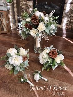 white flowers and greenery in a vase on a table next to a fire place