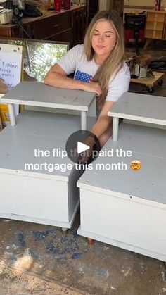 a woman sitting at a table with two drawers