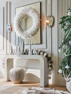 a room with a christmas tree and decorations on the wall next to a white bench