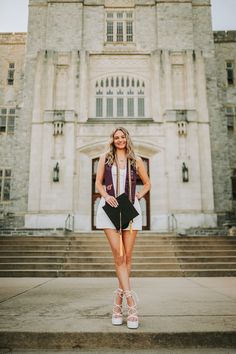 a woman standing in front of a large building with steps leading up to the entrance