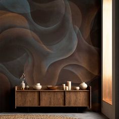 an artistic wallpaper with waves and vases on the sideboard in front of it