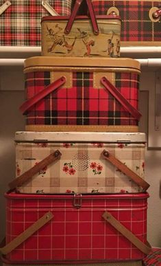 four suitcases stacked on top of each other in front of plaid wallpapered walls