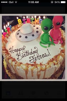 a birthday cake with candles and an alien on it