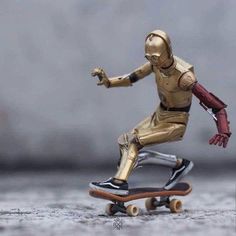 a toy figure is riding on a skateboard with one hand and the other leg extended