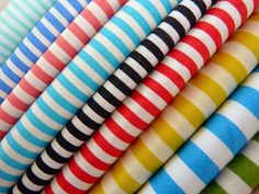 many different colored and striped fabrics stacked on top of each other