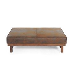 a brown leather ottoman sitting on top of a wooden table