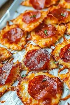 small pepperoni pizzas are on a baking sheet