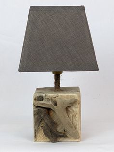 a lamp that is sitting on top of a block with a gray shade over it