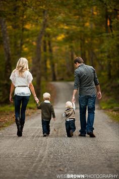 a family walking down the road holding hands