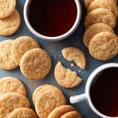 several cookies and two cups of tea on a table