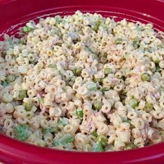 a red bowl filled with macaroni and peas