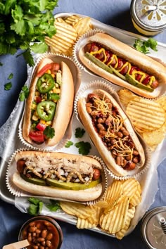 hot dogs and chips on a tray with condiments