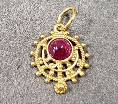 1. 18k Gold Ruby Pendant 2. Made to Order 3. Gemstone - Natural Ruby 4. Jewelry Type - Gold Ruby Pendant 5. Total weight - 0.910 Gram Approx.  6. Ruby Weight - 0.35 Carats  7. Gold Weight - 0.840 grams 8. Ruby Size - 4 MM 9. Gold Purity - 18k 10. Handmade Items 11. AAA Quality 12. 1 Quantity Available 13. Ready to dispatch in 1 - 2 days. 14. Stone Shape - Round Cabochon 15. Granules  Pictures are taken under natural and day light. Antique Jewelry With Round Stone For Gift, Byzantine Style Round Gemstone Jewelry, Handmade Gold Jewelry With Round Stone, Spiritual 22k Gold Necklace With Gemstone, Gold Cabochon Gemstones For Wedding, Gold Gemstones Birthstone, Yellow Gold Round Pendant Necklace In Temple Jewelry Style, Traditional Gold Jewelry With Cabochon, Round Gold Gemstones As Gifts