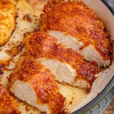 some chicken is cooking in a skillet on the stove with parmesan cheese and seasoning