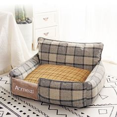 a dog bed on the floor next to a white rug with a black and brown checkered pattern