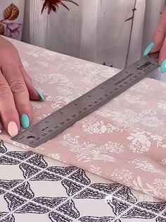 a woman is using a large ruler to measure the fabric on her tablecloths