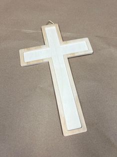 a white wooden cross sitting on top of a table