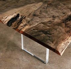 a wooden table with metal legs on concrete floor