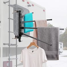 an rv with towels hanging from it's hooks and clothes on the rack outside