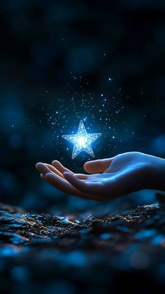 a person's hand holding a shining star