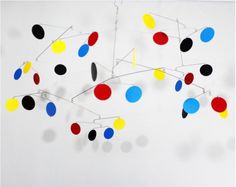 an abstract art piece with many different colored circles hanging from it's centerpiece