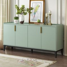 a green cabinet with plants and pictures on the top is in front of a window