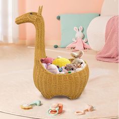 a wicker basket with stuffed animals in it on the floor next to pillows and toys