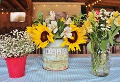 three vases with sunflowers and baby's breath are sitting on a table