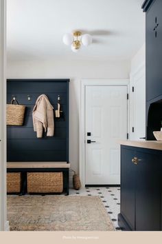 a coat rack with baskets on it next to a white door and blue cabinets in a room