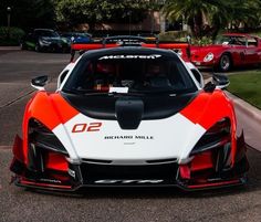 an orange and white sports car parked on the street