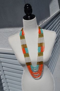 A gorgeous multi-color beaded necklace with dozens of individual strands of beads featuring colors of orange, blue, white and gold bead accents. Measures approximately 32" in total length. Buy 3 Ship Free (Put 3 items in your basket to realize free shipping) Orange Multi-strand Beaded Necklaces, Orange Bohemian Hand-strung Beaded Necklace, Handmade Orange Multi-strand Necklace, Orange Multi-strand Polished Beaded Necklaces, Vintage Orange Hand-strung Beaded Necklace, Blue Orange White, White Gold Necklaces, Blue Orange, Gold Beads