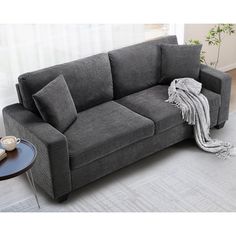 a gray couch sitting on top of a white rug