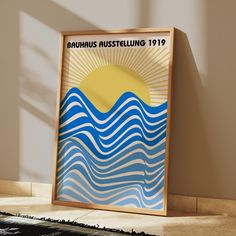 a framed poster is sitting on the floor in front of a wall with an advertisement for bauhus austellung 1911