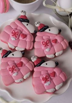 some pink decorated cookies on a white plate