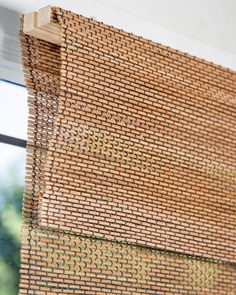 a close up view of a window with blinds made out of woven material and wood