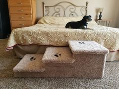 a dog laying on top of a bed next to two step stools in front of it