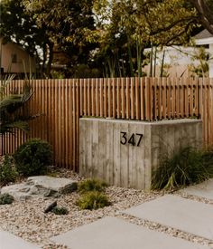 a wooden fence next to a cement box with the number 547 written on it