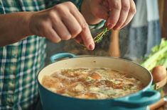 a person is stirring some soup in a pot