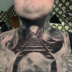 a man with a train track tattoo on his neck and chest is looking at the camera