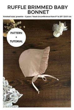 the ruffle brimmed baby bonnet sewing pattern is shown on a wooden table