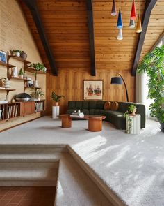 a living room filled with lots of furniture and decor on top of white carpeted flooring