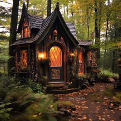 a small house in the woods with lots of leaves on the ground and trees around it