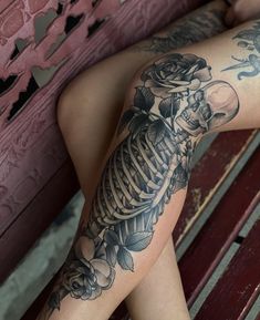 a woman sitting on top of a wooden bench covered in tattoos