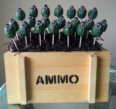 a wooden box filled with lollipops on top of a glass table next to a wall