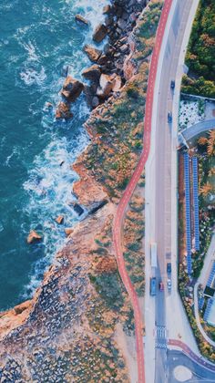 an aerial view of the ocean and road